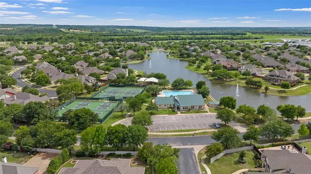 an aerial view of residential houses with outdoor space and lake view