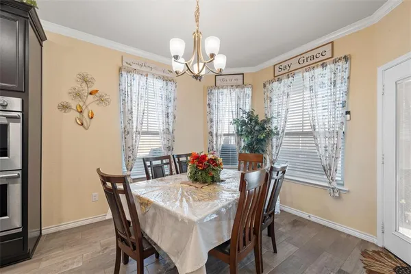 a dining room with furniture a chandelier and window