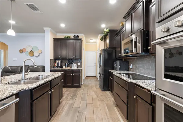 a kitchen with stainless steel appliances granite countertop a sink stove and refrigerator