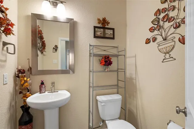 a bathroom with a sink mirror and toilet