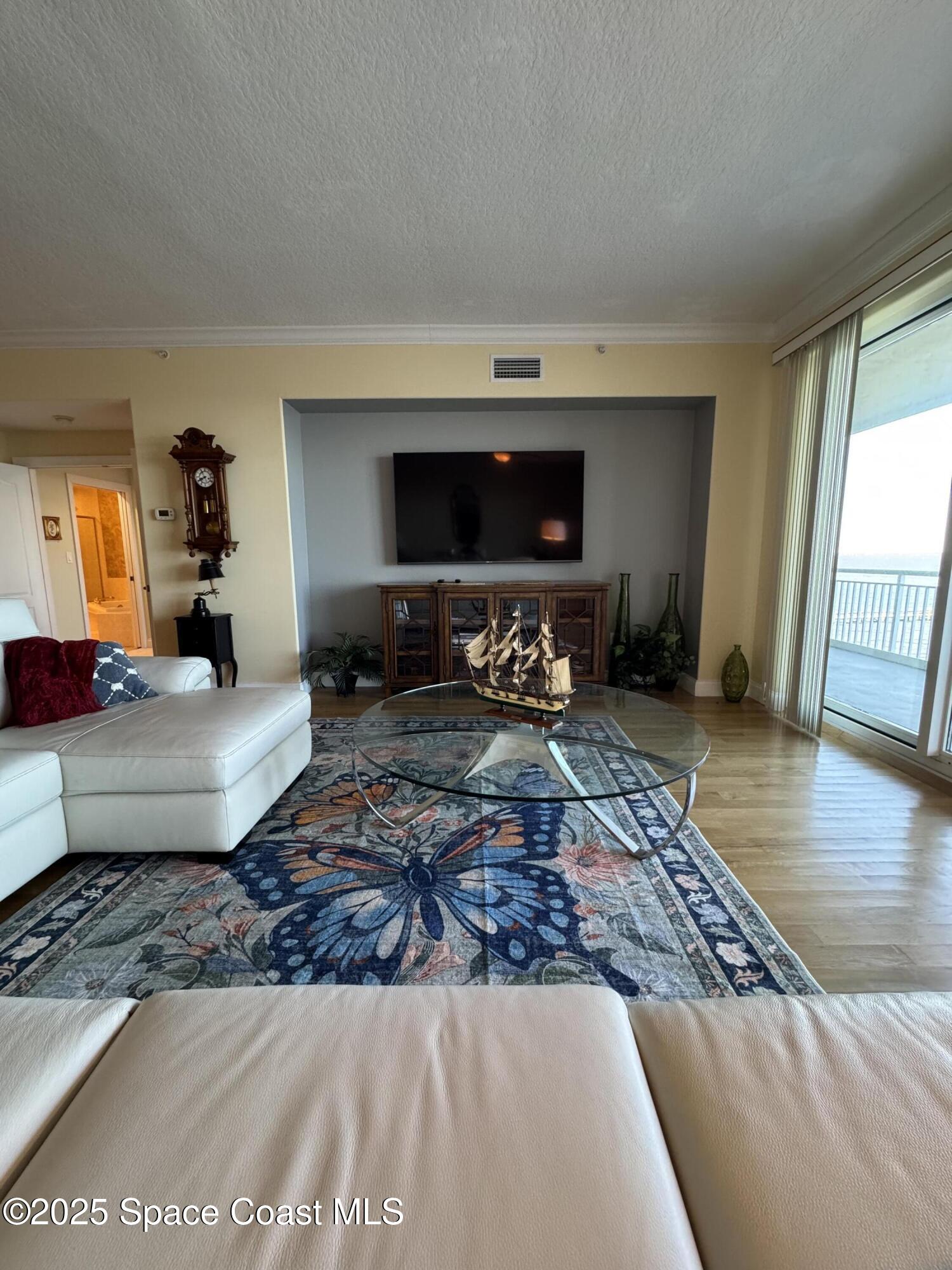 4955 Dixie Highway Northeast, Unit 502 Palm Bay, FL 32905 - Photo 12 of 51 a living room with furniture wooden floor and a flat screen tv