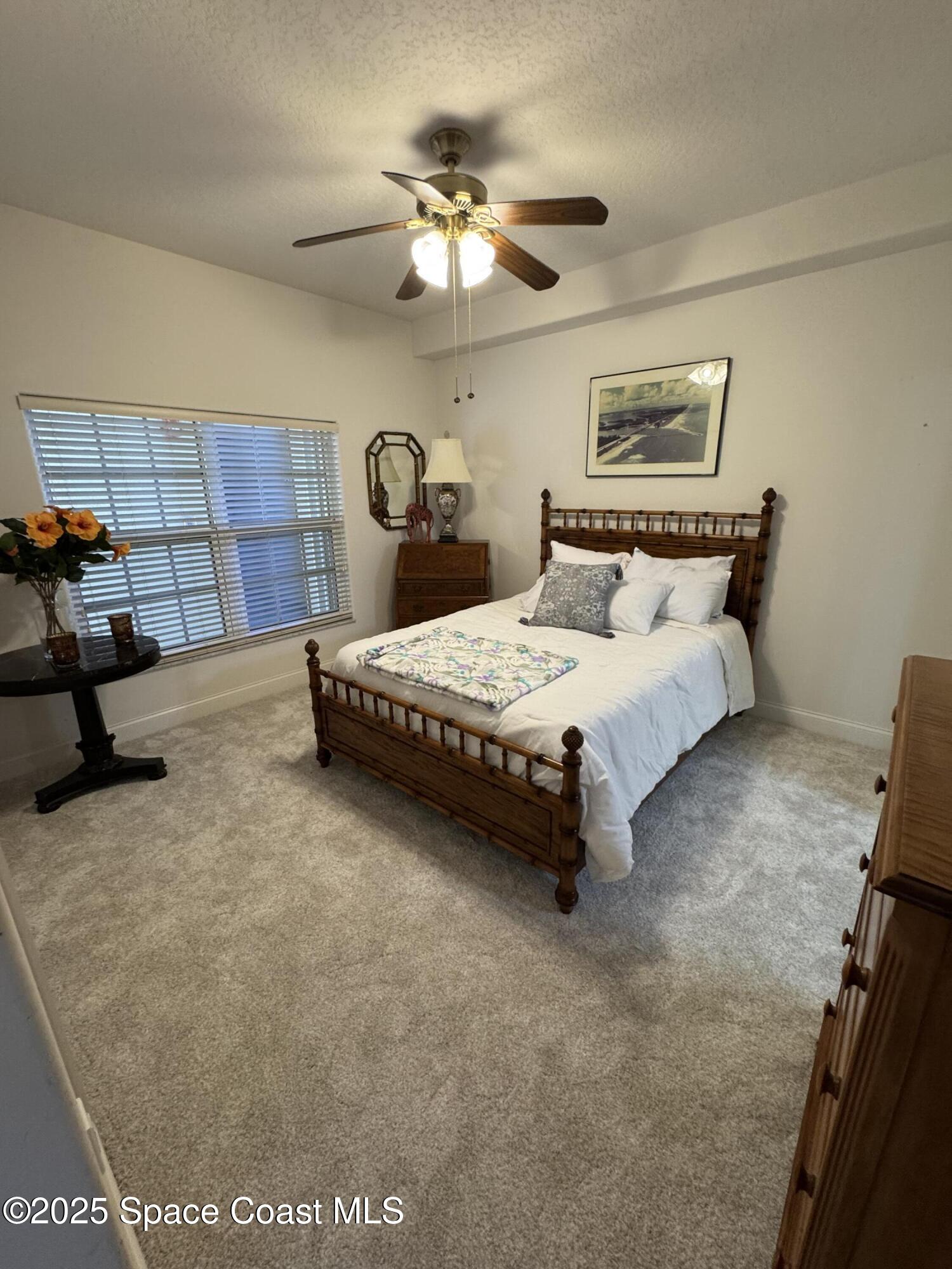 4955 Dixie Highway Northeast, Unit 502 Palm Bay, FL 32905 - Photo 20 of 51 a bedroom with a bed and a chandelier