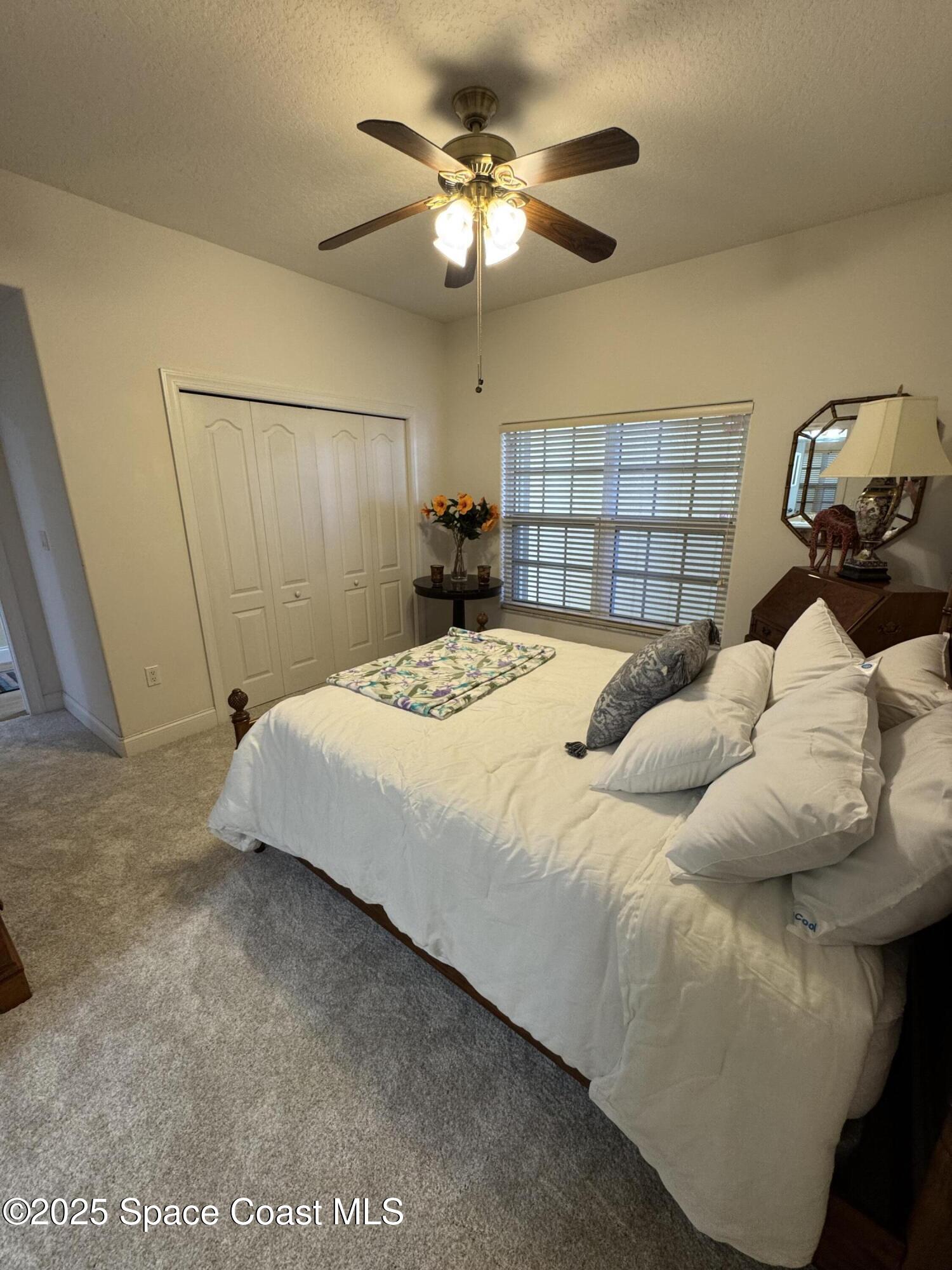 4955 Dixie Highway Northeast, Unit 502 Palm Bay, FL 32905 - Photo 22 of 51 a bedroom with a bed and a chandelier