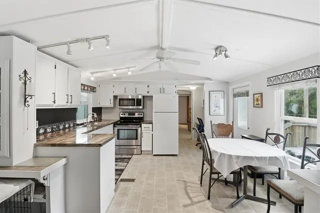 a kitchen with refrigerator and chairs
