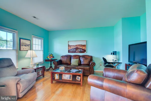 a dining room with furniture a chandelier and wooden floor