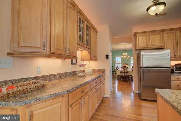 a bedroom with a bed a chandelier and a dresser