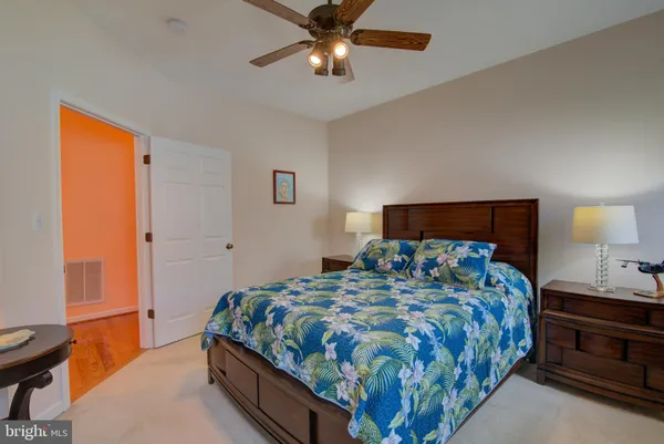 a bedroom with a bed and a lamp on dresser