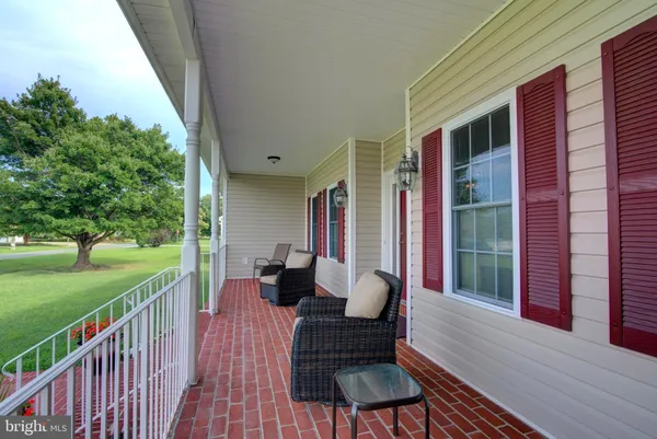 a view of a porch with furniture and a yard