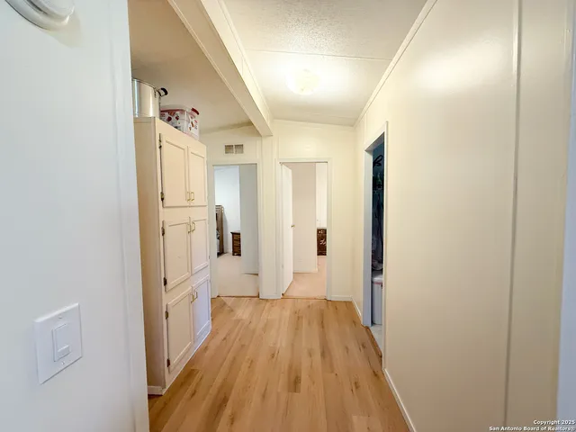 a view of a hallway with wooden floor and staircase