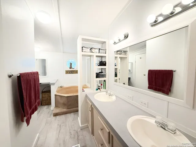 a bathroom with a tub sink and mirror