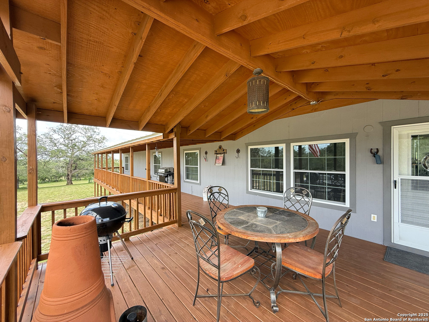 227 River Bluff Drive Lytle, TX 78052 - Photo 34 of 45 a view of a patio with table and chairs with wooden floor and fence