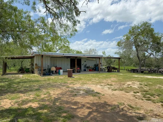 a view of a house with backyard and sitting area