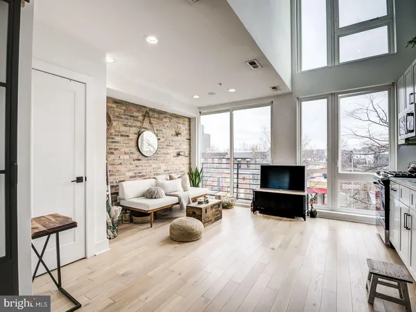 a living room with furniture a flat screen tv and a large window