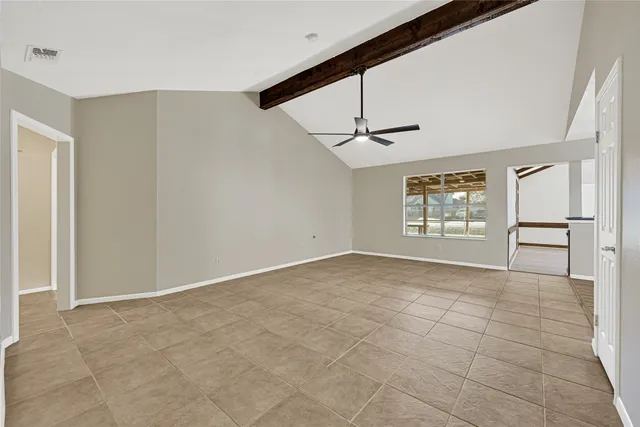 a view of an empty room and kitchen view