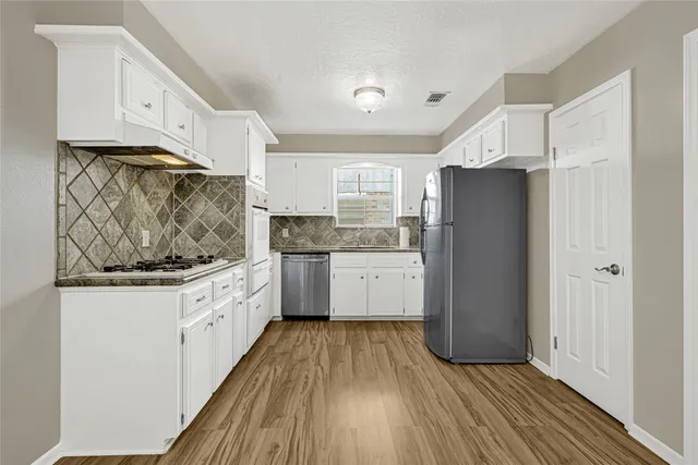 a kitchen with granite countertop white cabinets and white appliances