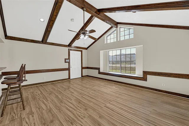 a view of empty room with wooden floor