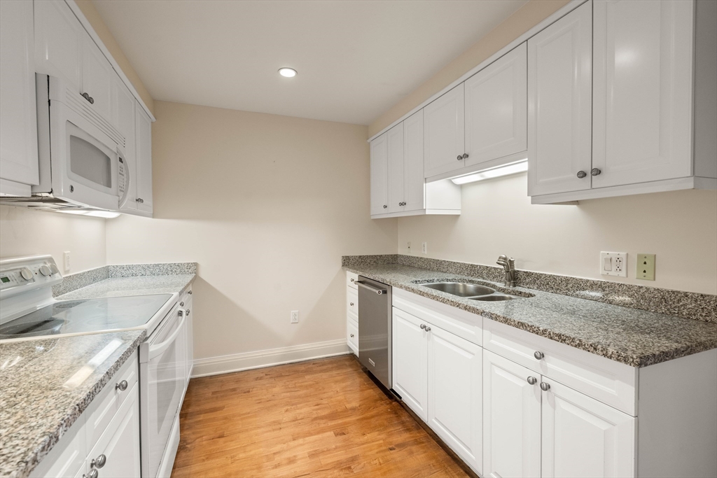 1 Huntington Avenue, Unit 904 Boston, MA 02116 - Photo 2 of 10 a kitchen with granite countertop a sink stove and cabinets