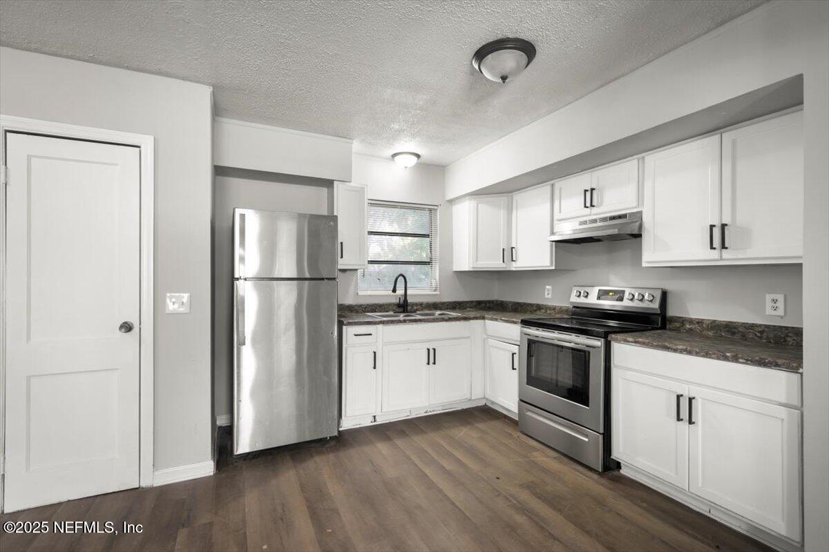 7567 Strato Road Jacksonville, FL 32210 - Photo 11 of 26 a kitchen with stainless steel appliances granite countertop a refrigerator sink and white cabinets