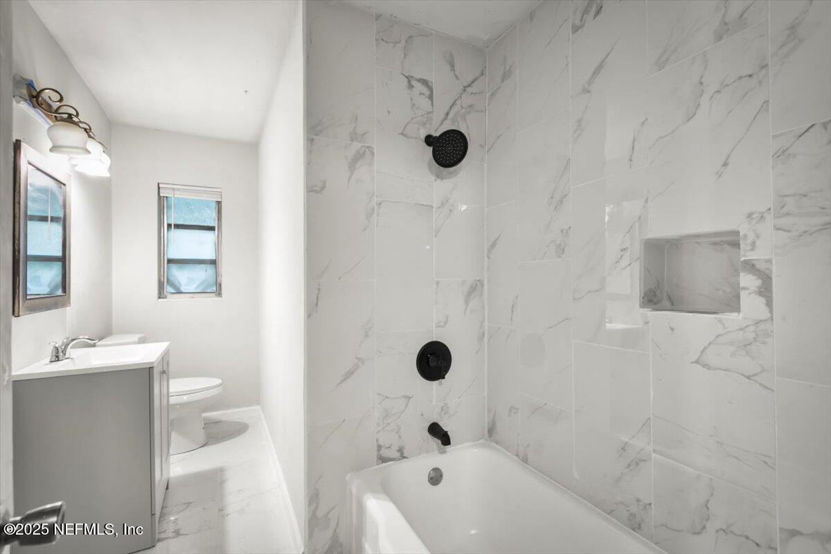 7567 Strato Road Jacksonville, FL 32210 - Photo 15 of 26 a bathroom with a bathtub shower sink and toilet