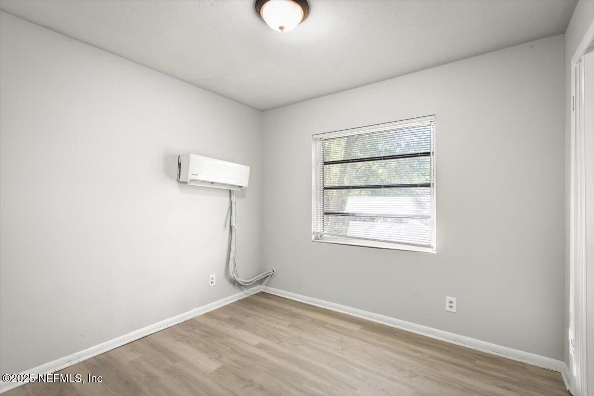 7567 Strato Road Jacksonville, FL 32210 - Photo 17 of 26 an empty room with a window and wooden floor