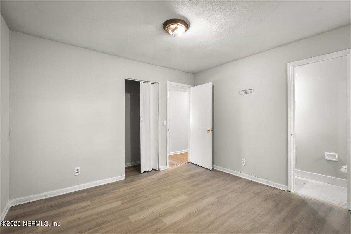 7567 Strato Road Jacksonville, FL 32210 - Photo 19 of 26 an empty room with wooden floor and windows