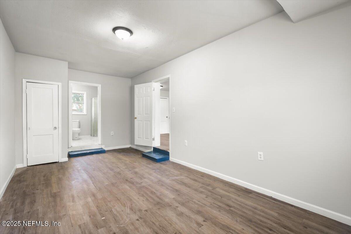 7567 Strato Road Jacksonville, FL 32210 - Photo 23 of 26 an empty room with wooden floor and windows