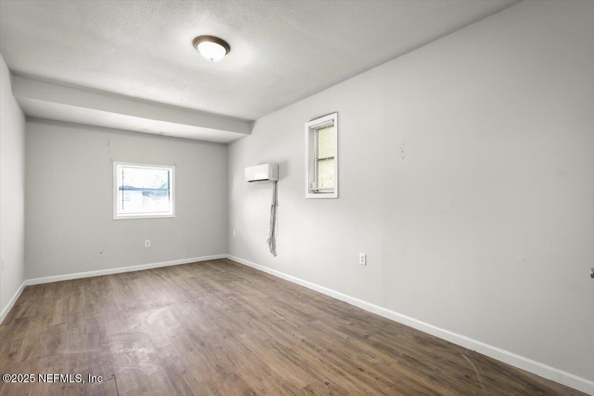 7567 Strato Road Jacksonville, FL 32210 - Photo 24 of 26 an empty room with wooden floor and windows