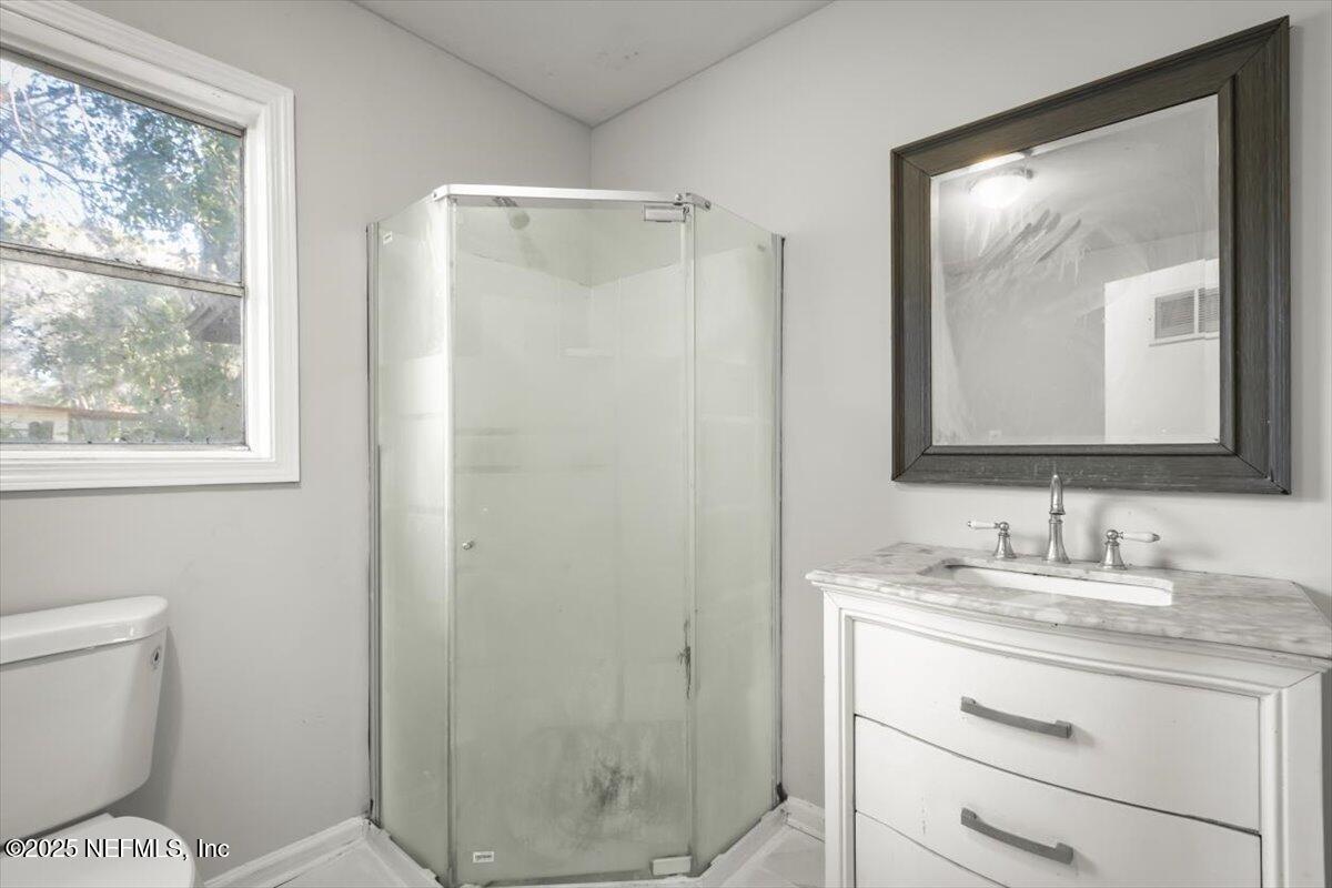 7567 Strato Road Jacksonville, FL 32210 - Photo 25 of 26 a bathroom with a toilet sink vanity and mirror