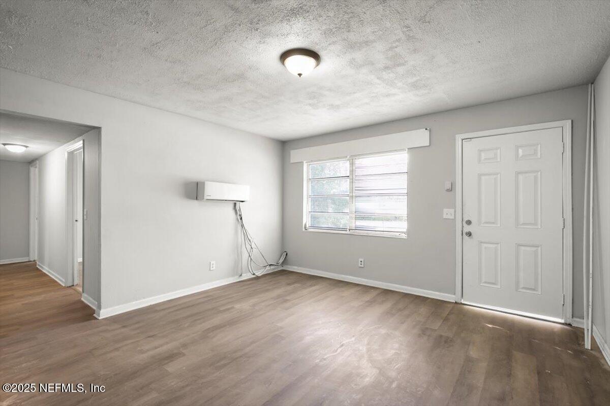 7567 Strato Road Jacksonville, FL 32210 - Photo 6 of 26 an empty room with wooden floor and windows