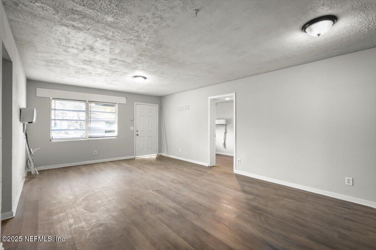 7567 Strato Road Jacksonville, FL 32210 - Photo 8 of 26 an empty room with wooden floor and windows