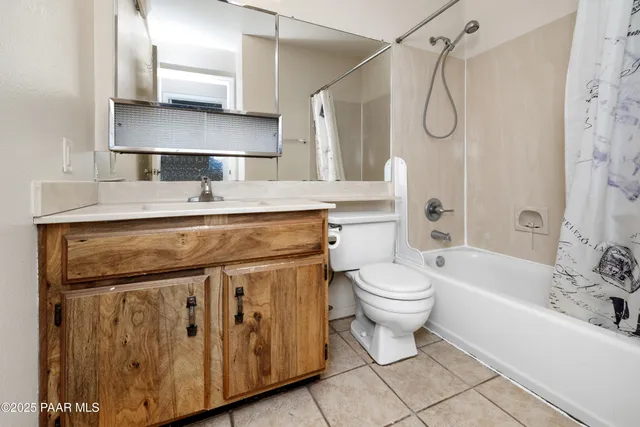 a bathroom with a granite countertop sink a toilet a mirror and bathtub
