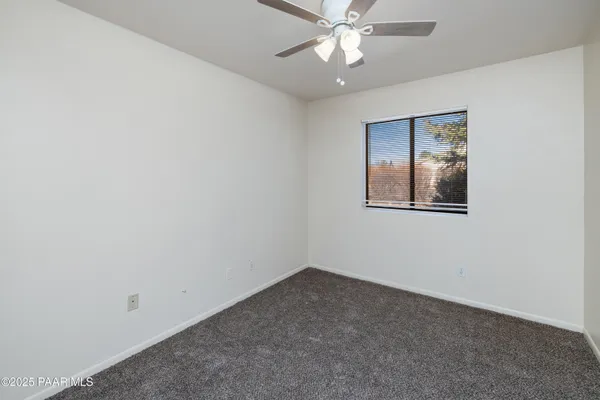 an empty room with a fan and a fan