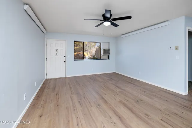 a view of empty room with wooden floor