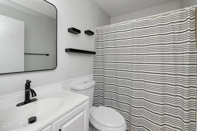 a bathroom with a sink a toilet and mirror