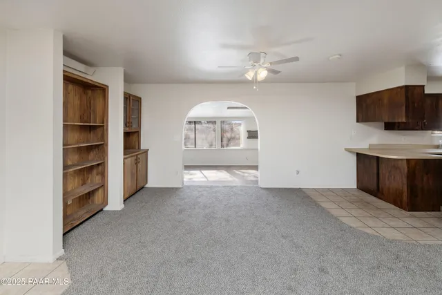 wooden floor in an empty room with a fireplace and a window