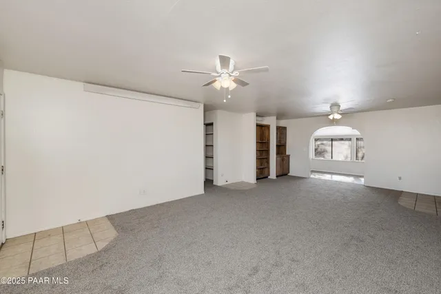 a view of a livingroom with a ceiling fan and window