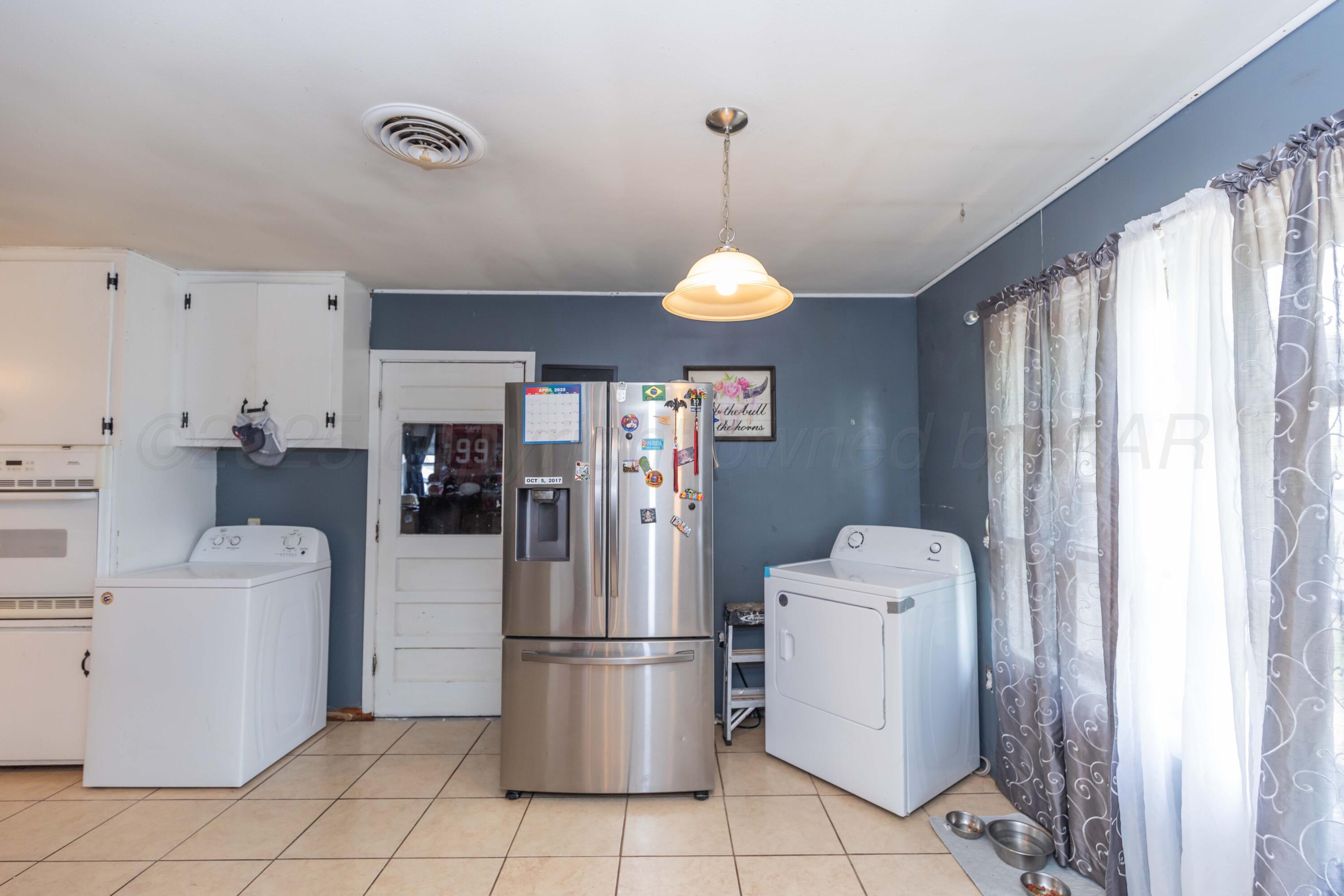 501 Southeast 2nd Street Tulia, TX 79088 - Photo 11 of 32 a kitchen with a refrigerator a stove top oven a sink and a window