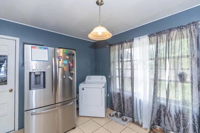 a kitchen with stainless steel appliances granite countertop a refrigerator and a window