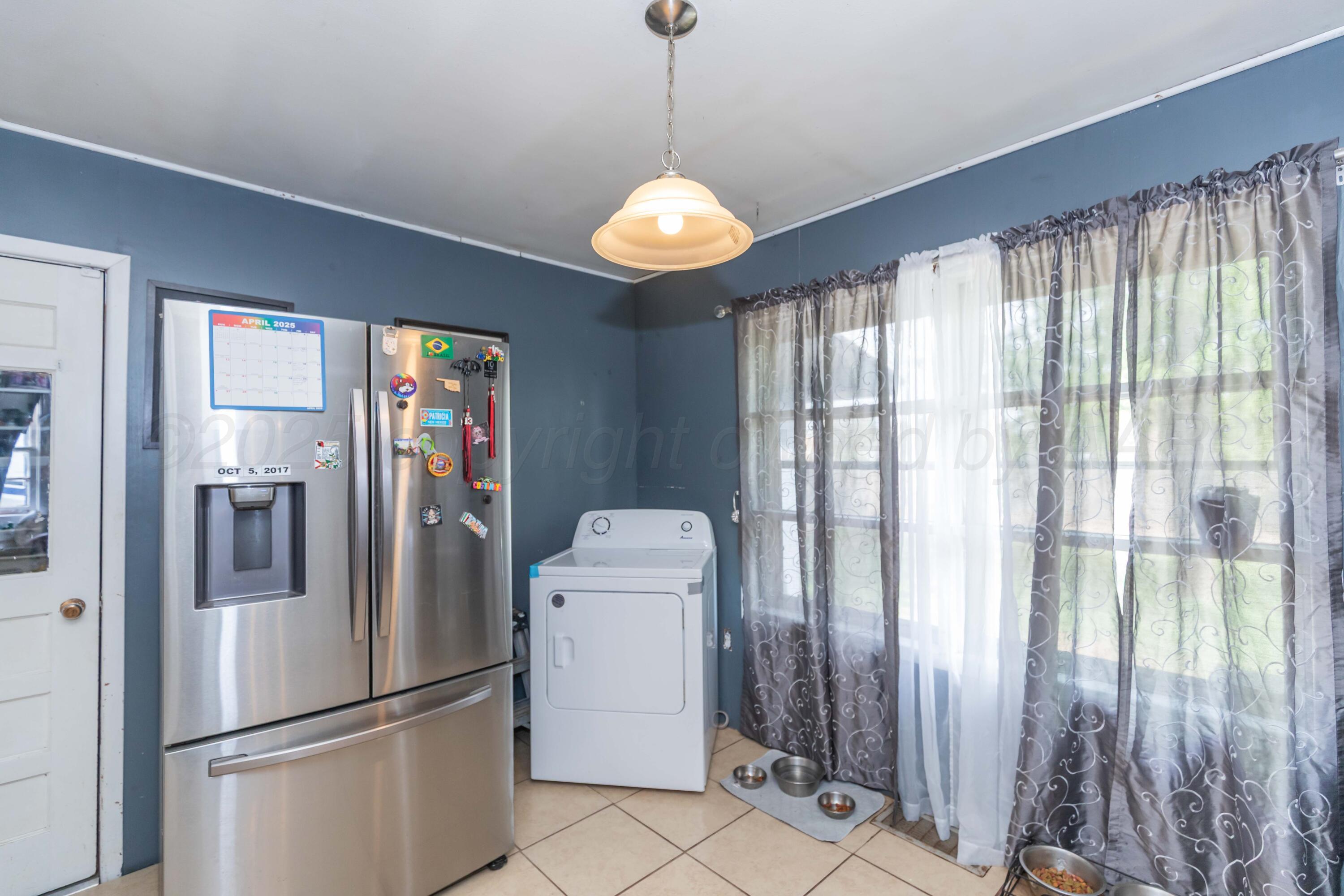 501 Southeast 2nd Street Tulia, TX 79088 - Photo 12 of 32 a kitchen with stainless steel appliances granite countertop a refrigerator and a window