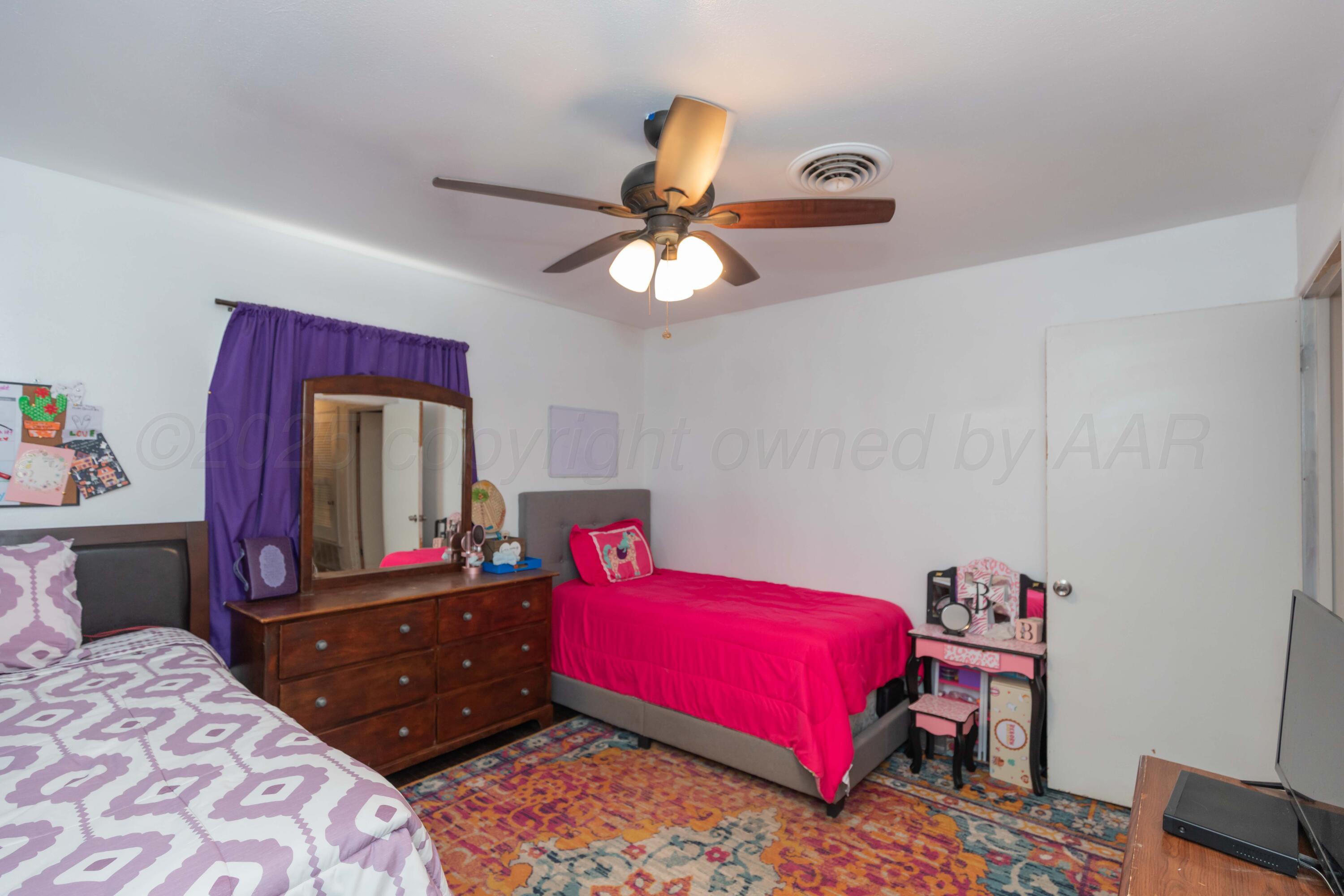 501 Southeast 2nd Street Tulia, TX 79088 - Photo 19 of 32 a bedroom with a bed and a dresser in it
