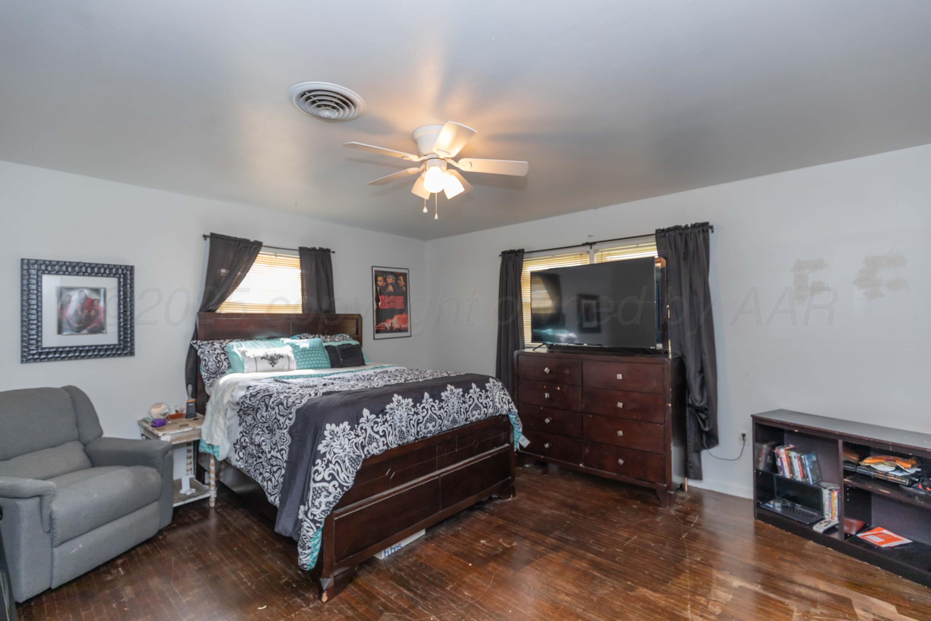 501 Southeast 2nd Street Tulia, TX 79088 - Photo 20 of 32 a bedroom with a bed and a chandelier
