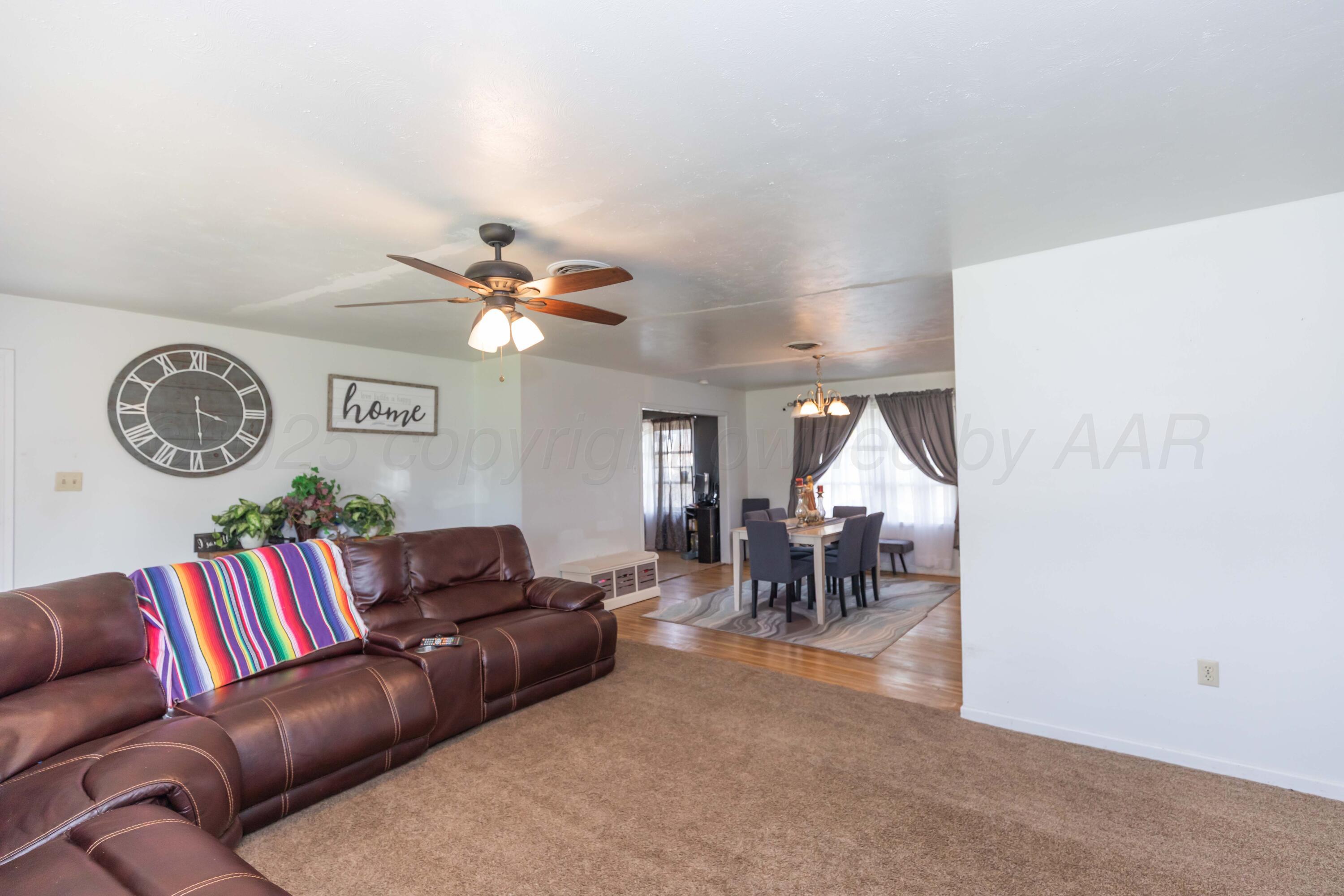 501 Southeast 2nd Street Tulia, TX 79088 - Photo 5 of 32 a living room with furniture a clock and a window
