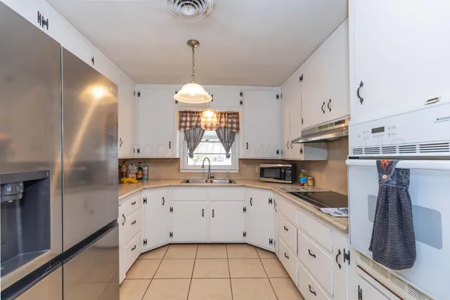 a kitchen with stainless steel appliances a sink a stove and refrigerator