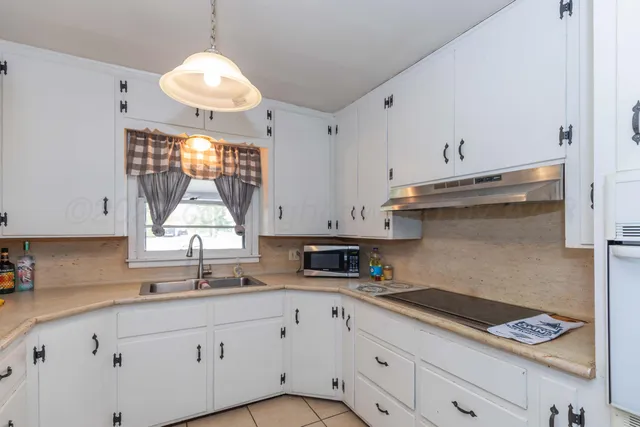 a kitchen with white cabinets and appliances