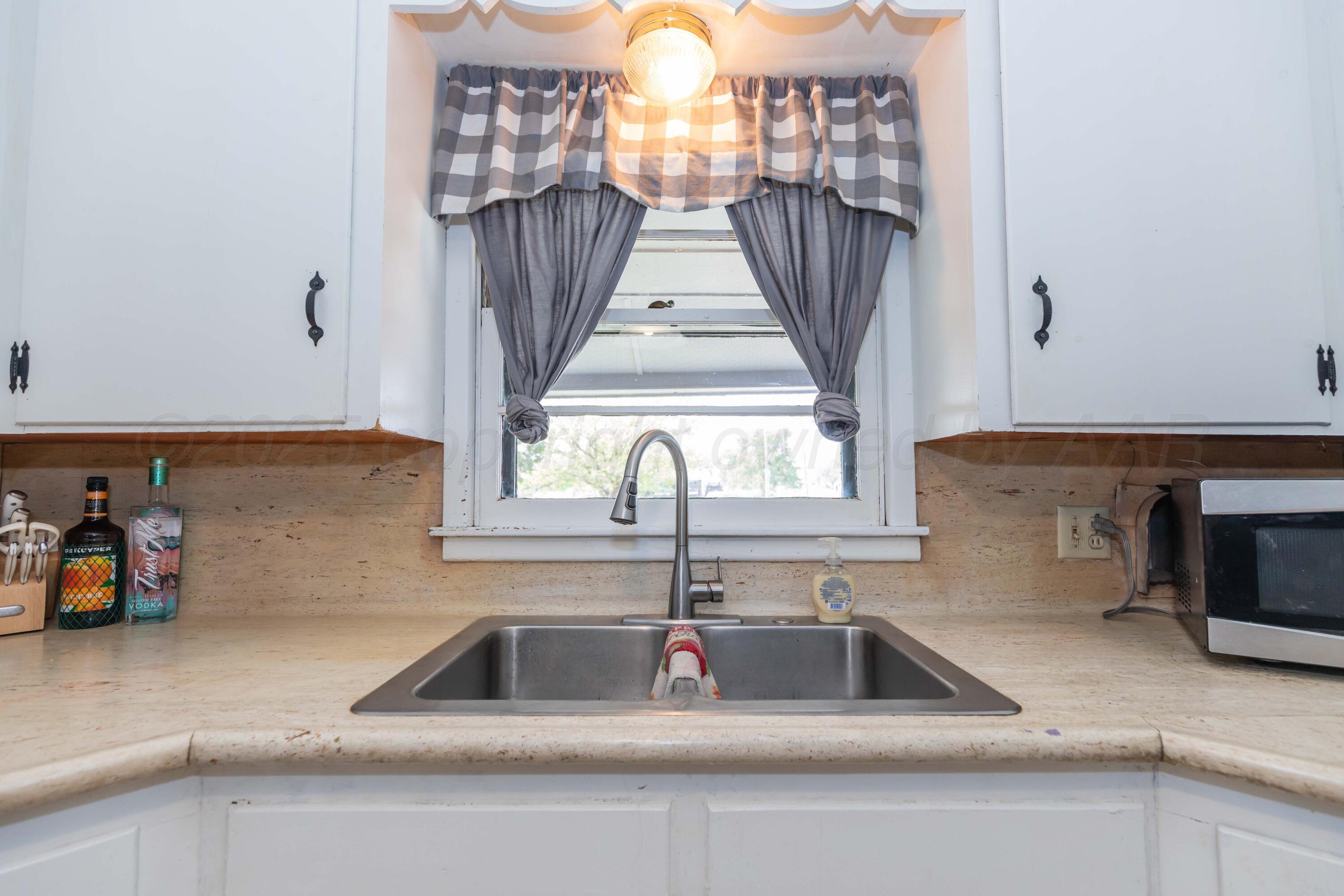 501 Southeast 2nd Street Tulia, TX 79088 - Photo 9 of 32 a kitchen with a sink and a window