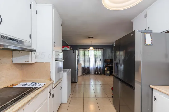 a kitchen with stainless steel appliances granite countertop a refrigerator and a stove