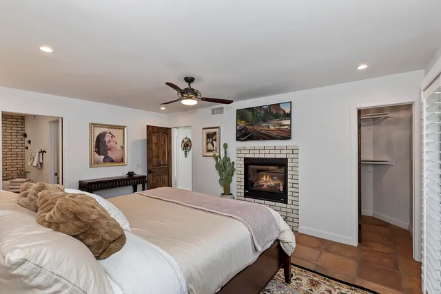 a bedroom with a large bed and a fireplace