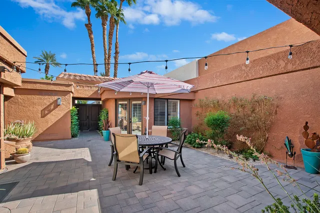a view of a patio with a table and chairs under an umbrella
