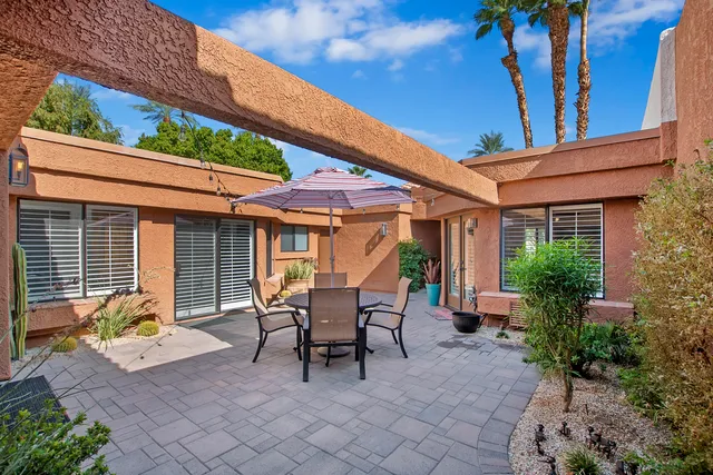 a view of a patio with table and chairs and potted plants