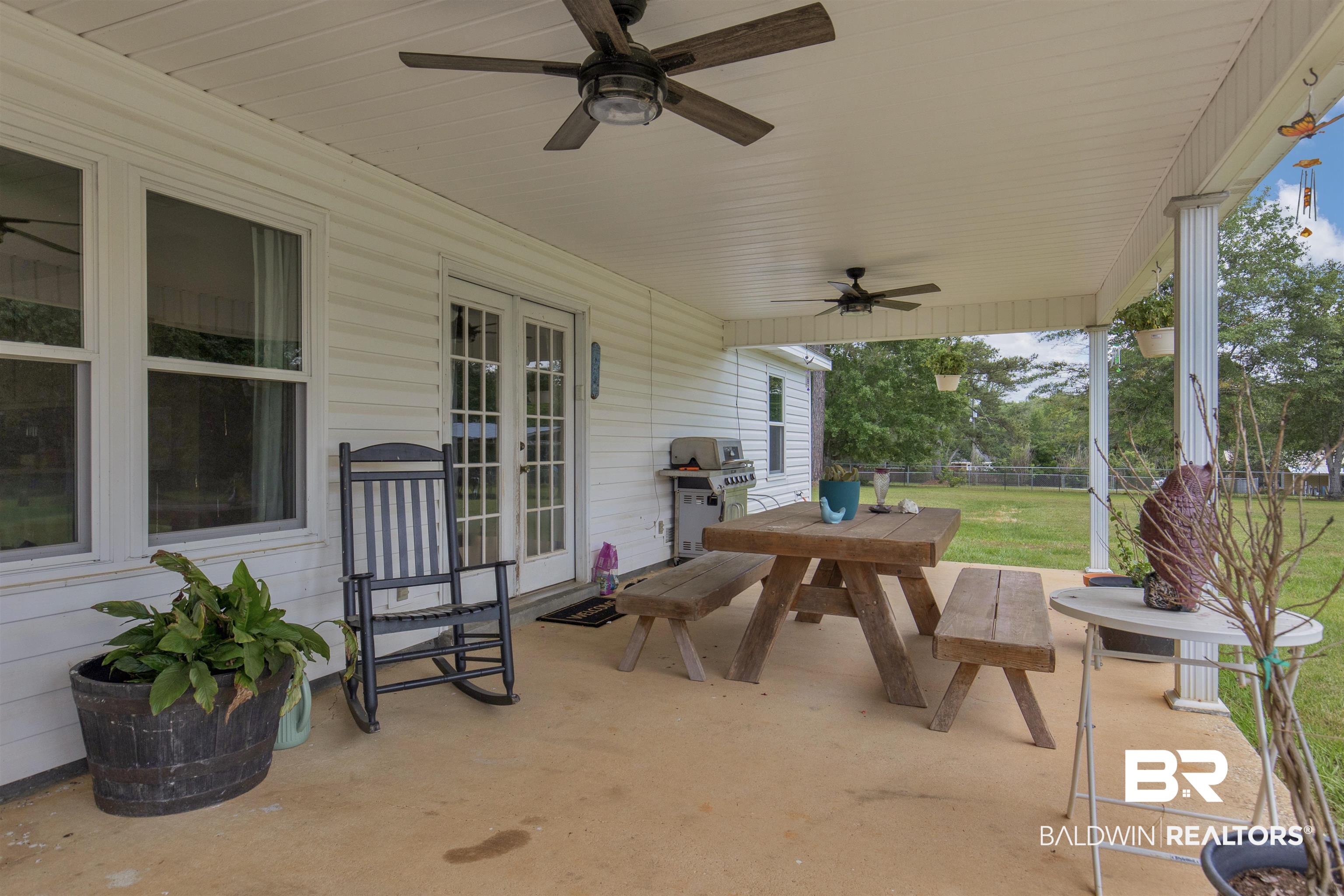 13925 Fort Lake Road Grand Bay, AL 36541 - Photo 23 of 37 View of patio / terrace featuring fence, a ceiling fan, outdoor dining space, and a grill